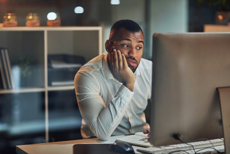 stressed man working at night in an office