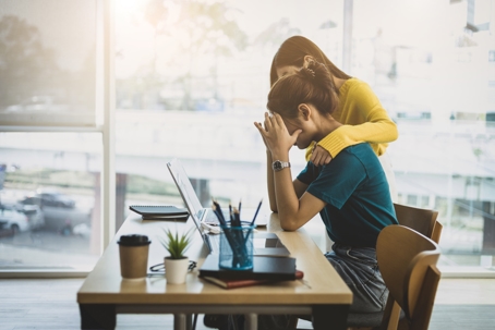 female employees comforting each other in the office